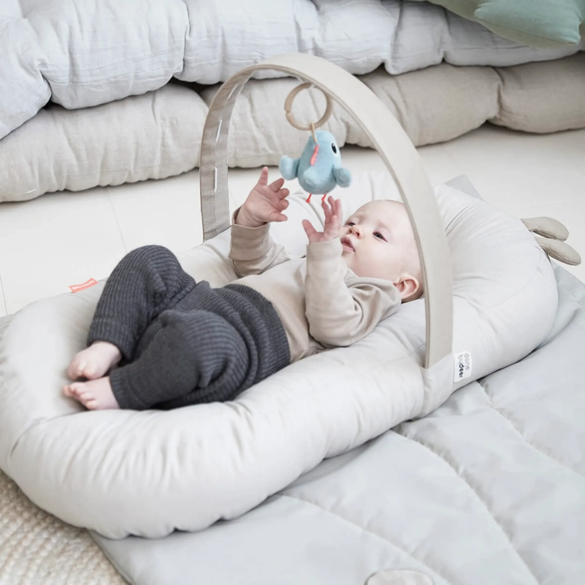 DONE BY DEER Cozy lounger With Activity Arch - Raffi Sand